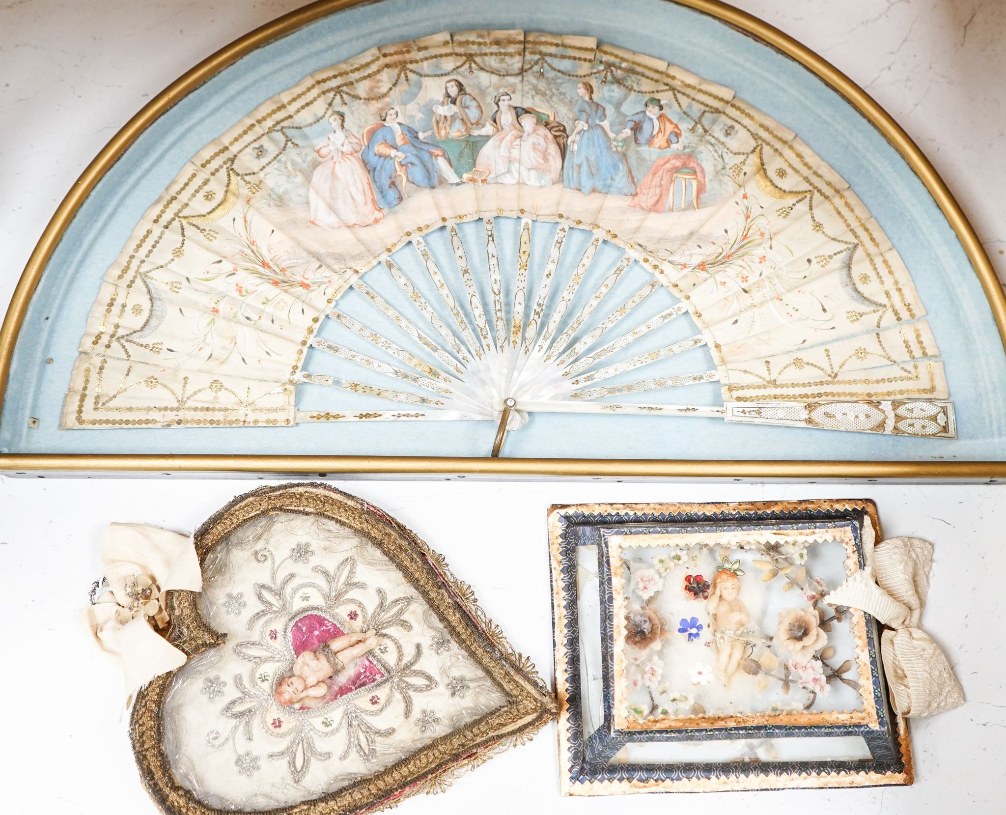 A late 18th / early 19th century Continental figurative framed fan and two religious cased effigy of baby Jesus